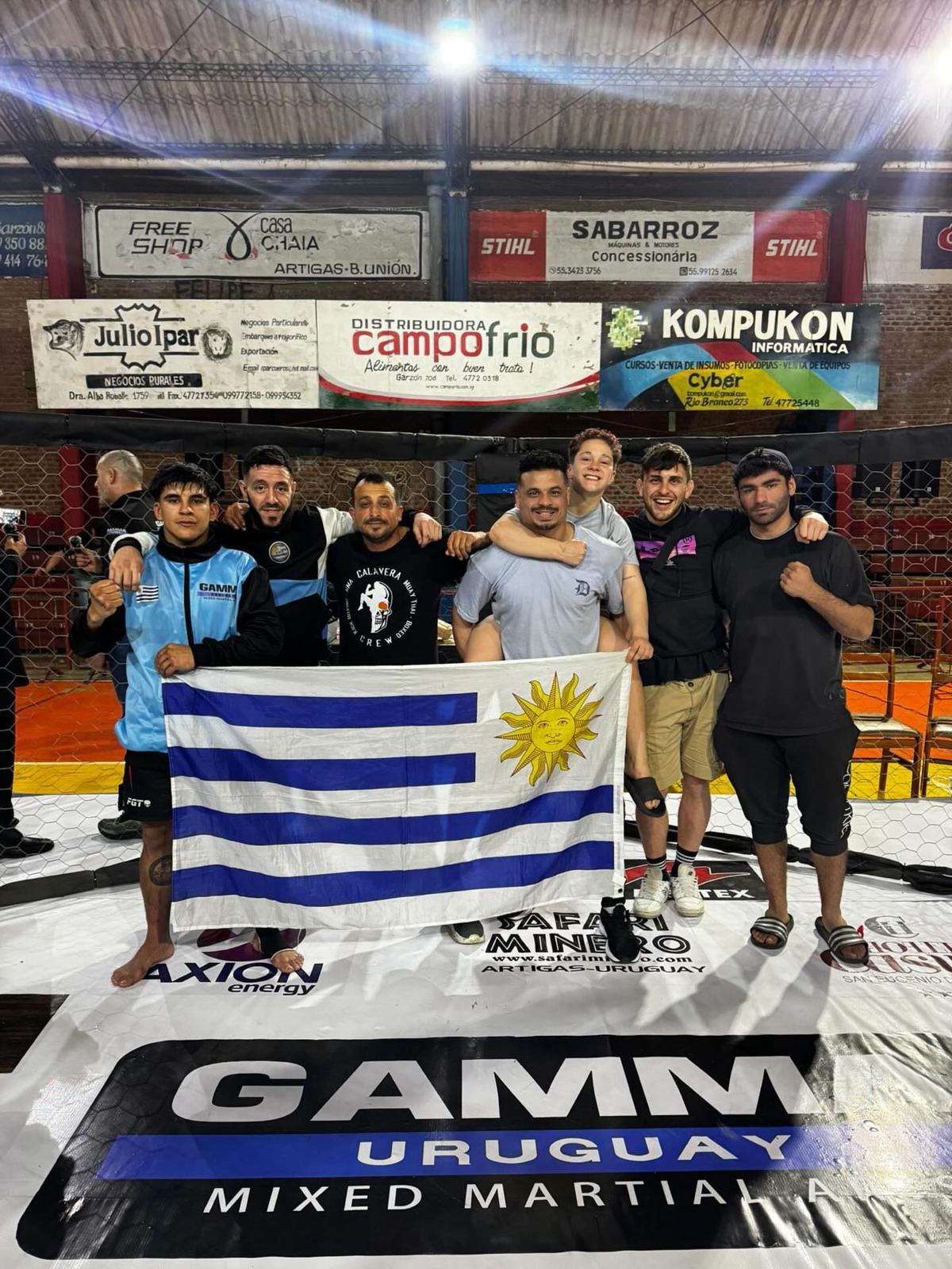 Equipo de Calavera Crew con la bandera de Uruguay dentro de la jaula tras competir.